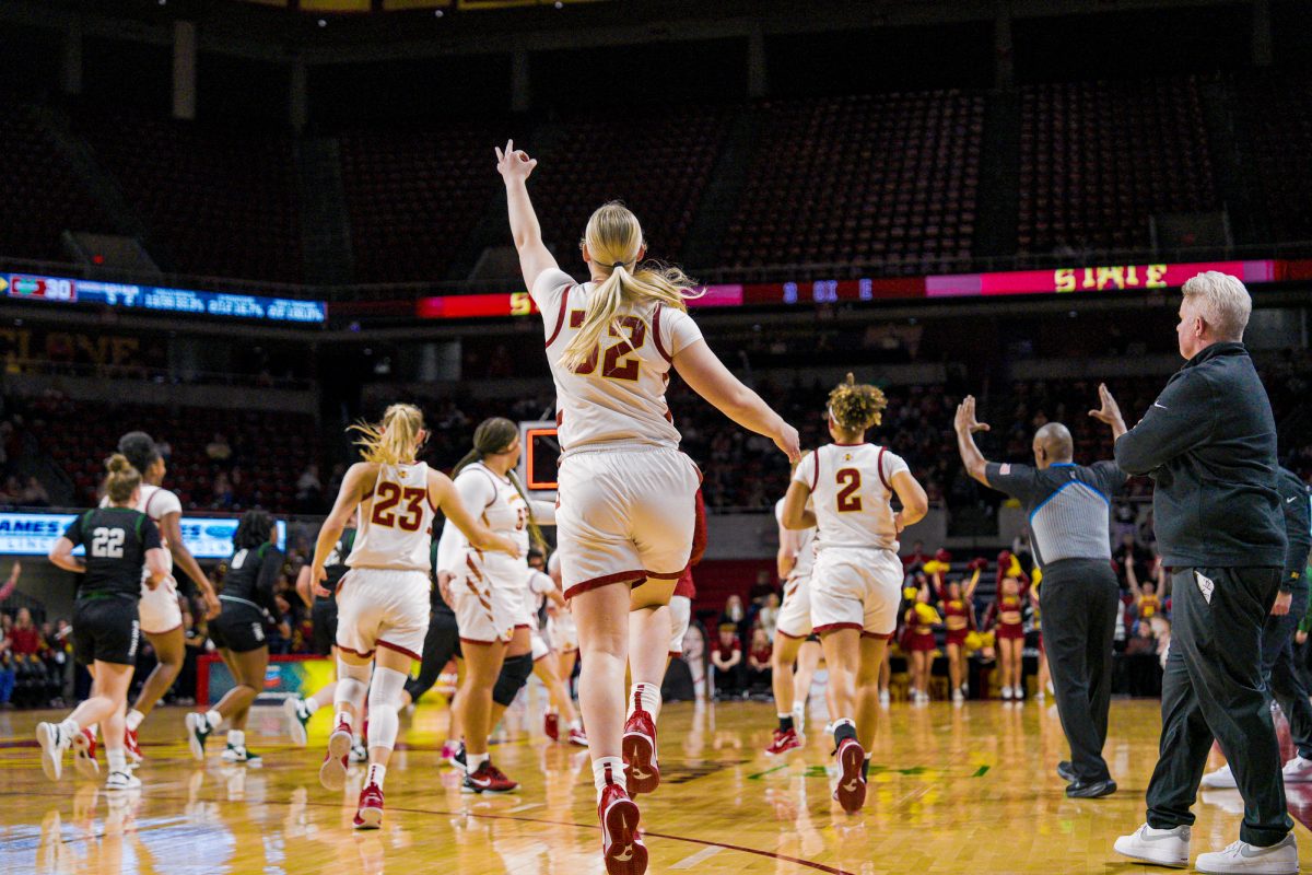 Iowa State Aili Tanke (32) runs onto the court with the rest of her team after the third quarter, three fingers shown on her hand as her teammate made a three point to finish the quarter against Upstate, Hilton Coliseum, Dec. 3, 2024.