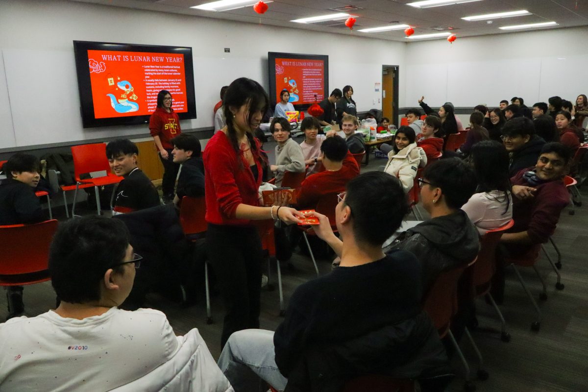 A member of the club receives a Red Envelope for speaking his Lunar New Year wishes at the ASU and VSA Lunar New Year event, taken on January 29, 2025, at Pearson hall at Iowa State University.