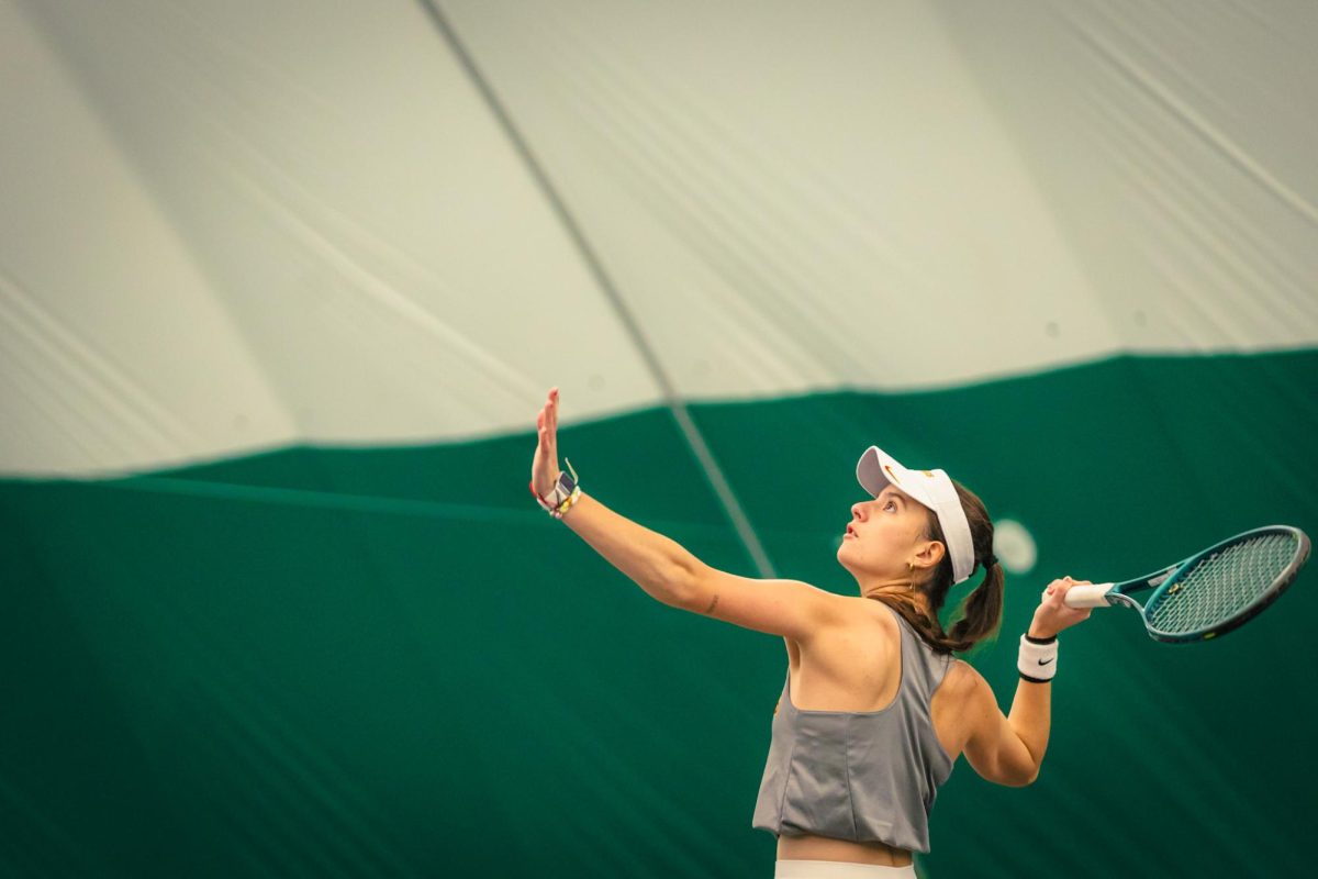 Christina Ramos Sierra goes for an over head during the Iowa State University vs. University of Wyoming tennis meet, Feb. 8, 2025, Iowa State Tennis Center, Ames, Iowa. 