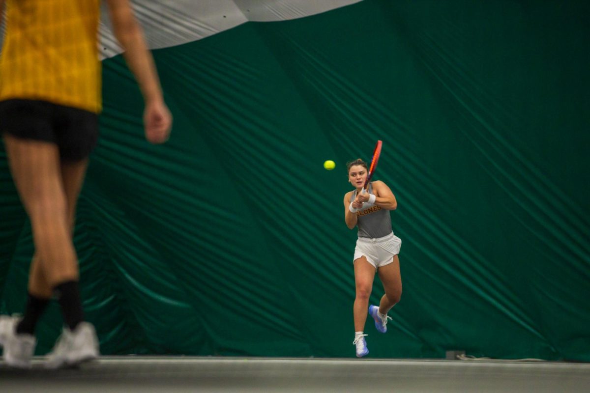 Gabriela Felix goes for a backhand during the Iowa State University vs. University of Wyoming tennis meet, Feb. 8, 2025, Iowa State Tennis Center, Ames, Iowa. 