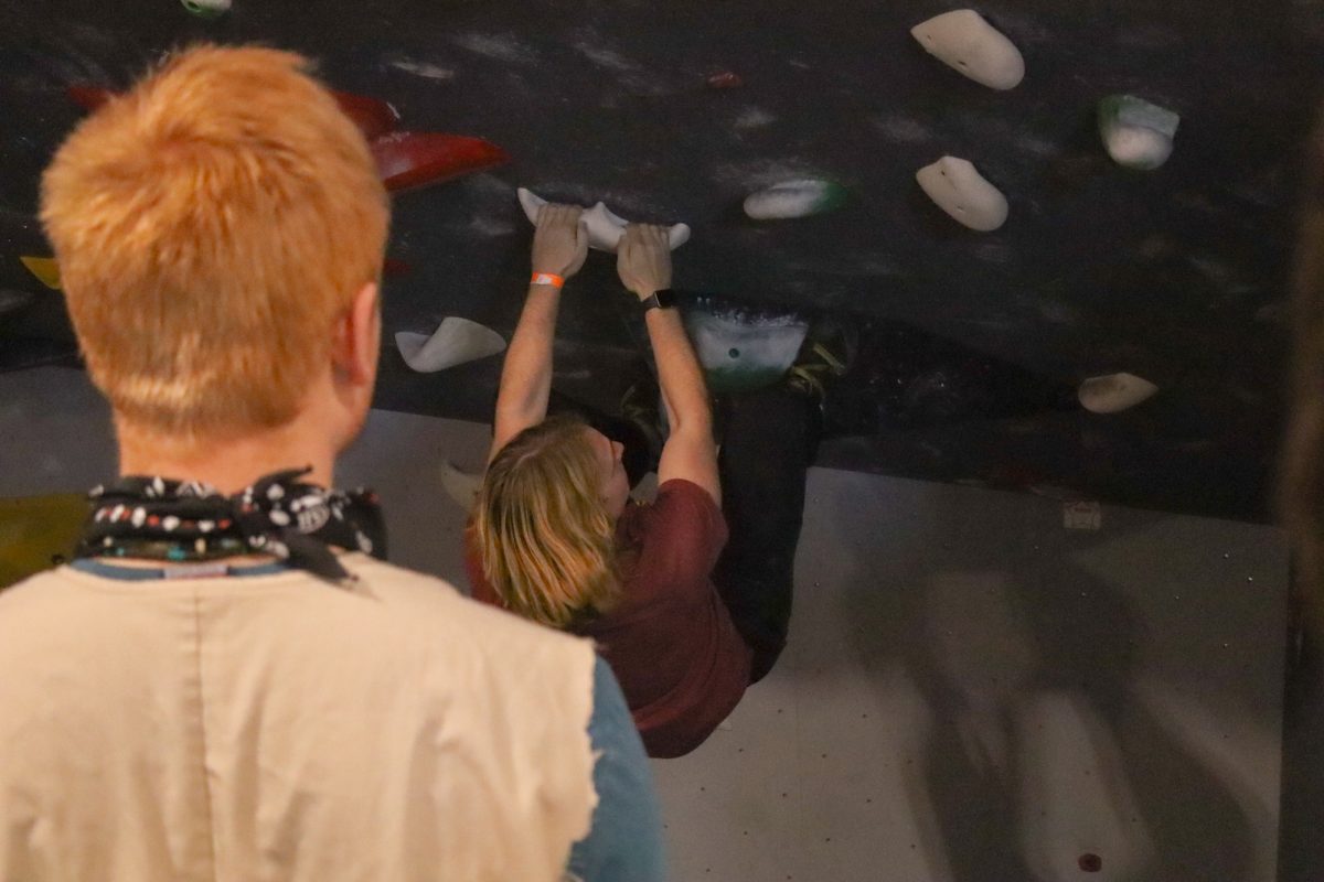 Iowa State Mountaineering and Climbing Club member T.J. Hocraffer watches member Karson Goone start off the overhung white route. Taken on Mar. 1, 2025, at Rendezvous Climbing Gym, Kansas City.