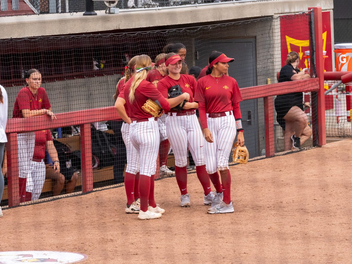 Iowa State Softball teamates together before the start of a new inning, Sept. 21, Iowa State Sports Complex, Ames, Iowa