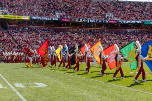 Cy and members of the Iowa State band carry flags of other colleges across the field before the Iowa vs. Iowa State football game at Jack Trice Stadium, Ames, Iowa, Sept. 6, 2025.