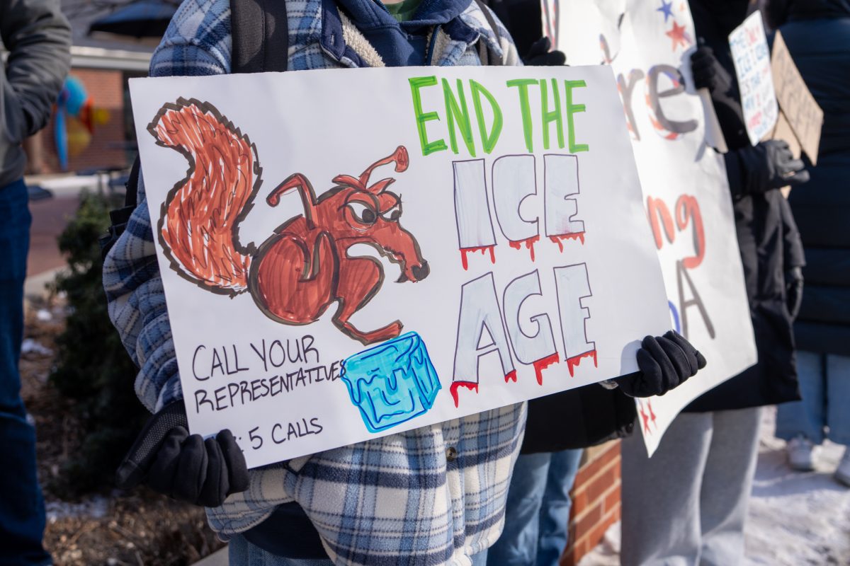 An Iowa State student holds a sign reading "End the ICE Age" referencing the Ice Age movie series during a student-led demonstration against ICE activities outside of Parks Library in Ames, Iowa, Jan. 30, 2026.