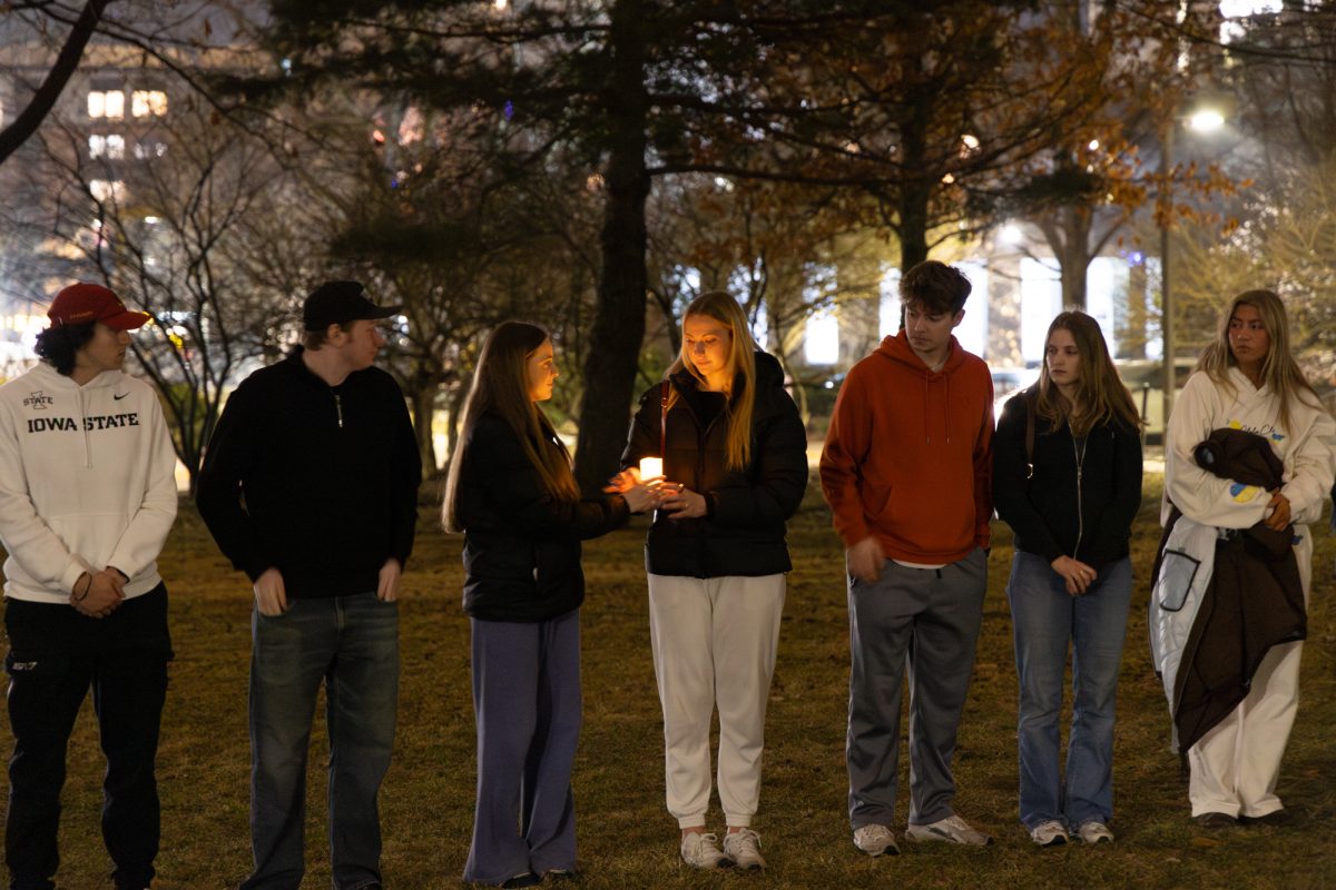 Iowa State students passing around the Candle at Theta Chi's candlelight vigil, South Campanile Lawn, Ames, Iowa, March 4, 2026.
