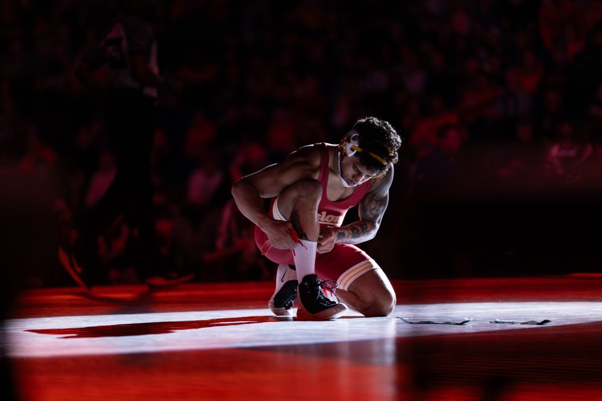 Anthony Echemendia adjusts his sock before putting on the red ankle strap. Big 12 Wrestling Tournament, session four, BOK Center, Tulsa, Oklahoma, March 7, 2026.