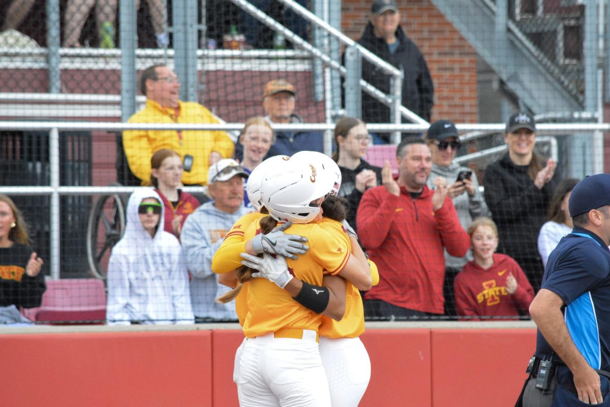 Tatum Johnson (22) and teammates hugging after Johnson hits a home run during the Iowa State vs. Oklahoma State softball game at Cyclone Sports Complex, Ames, Iowa, April 12, 2026.