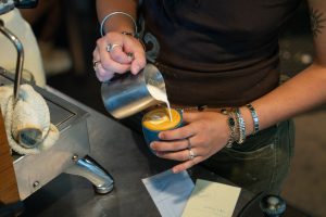 A barista with Lockwood Cafe creates foam art on a drink order at their location in Ames, Iowa, July 11, 2026.
