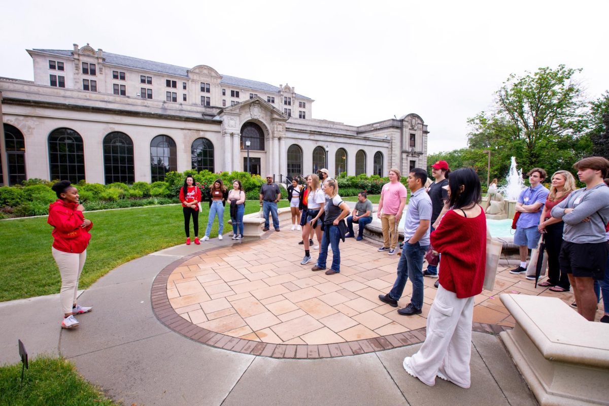 Cyclone Aide Naledi Kekana, left, welcomes a group of incoming freshmen with their families at the outset of an orientation campus tour outside the Memorial Union, Ames, Iowa, 2022. Courtesy of Inside Iowa State.