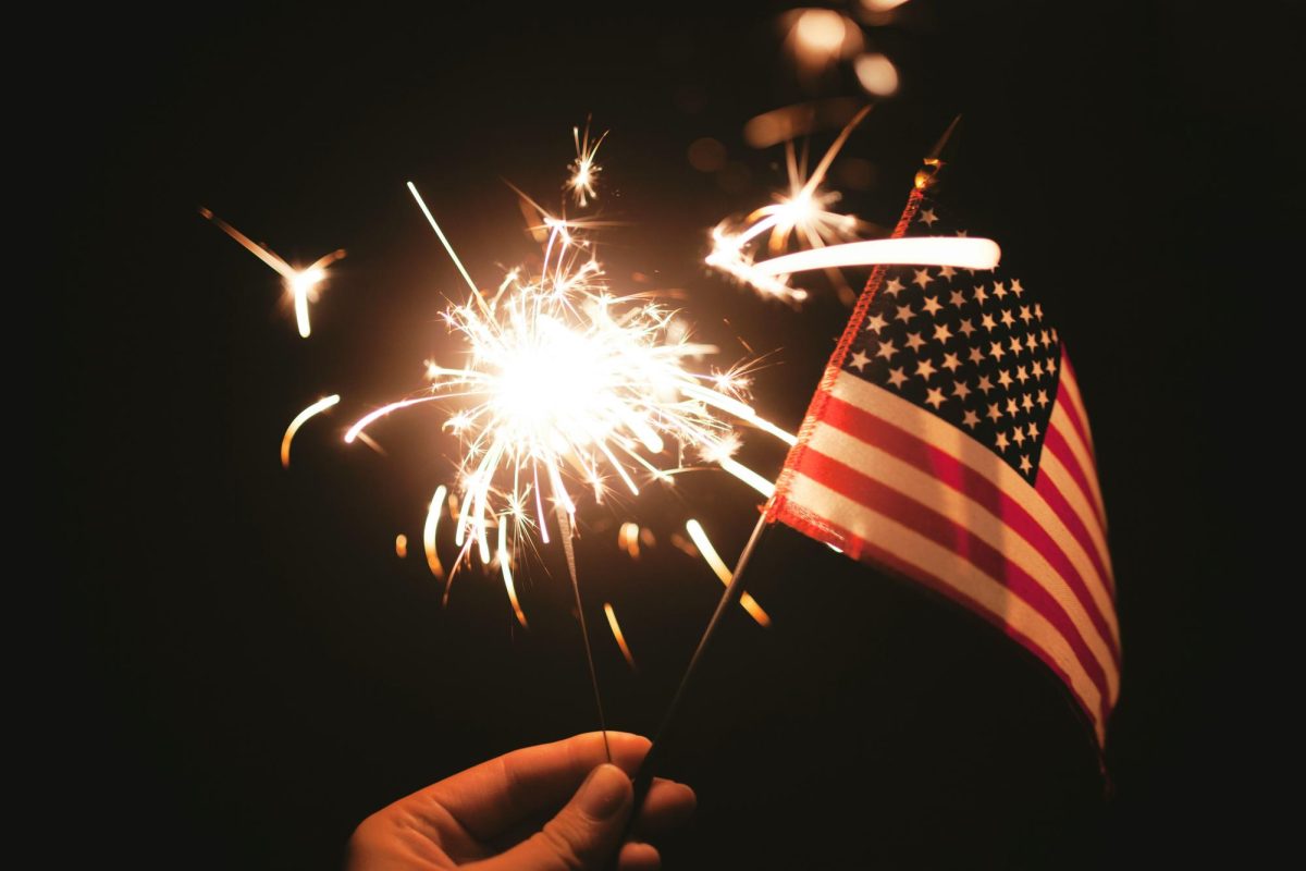 Sparklers and an American flag. Courtesy of Unsplash.